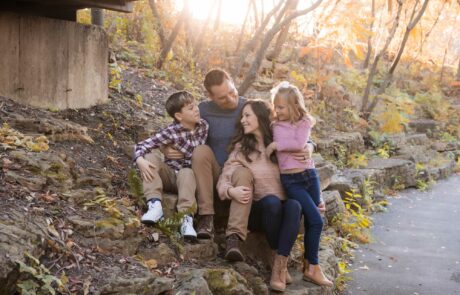 fall family sitting under bridge homepage