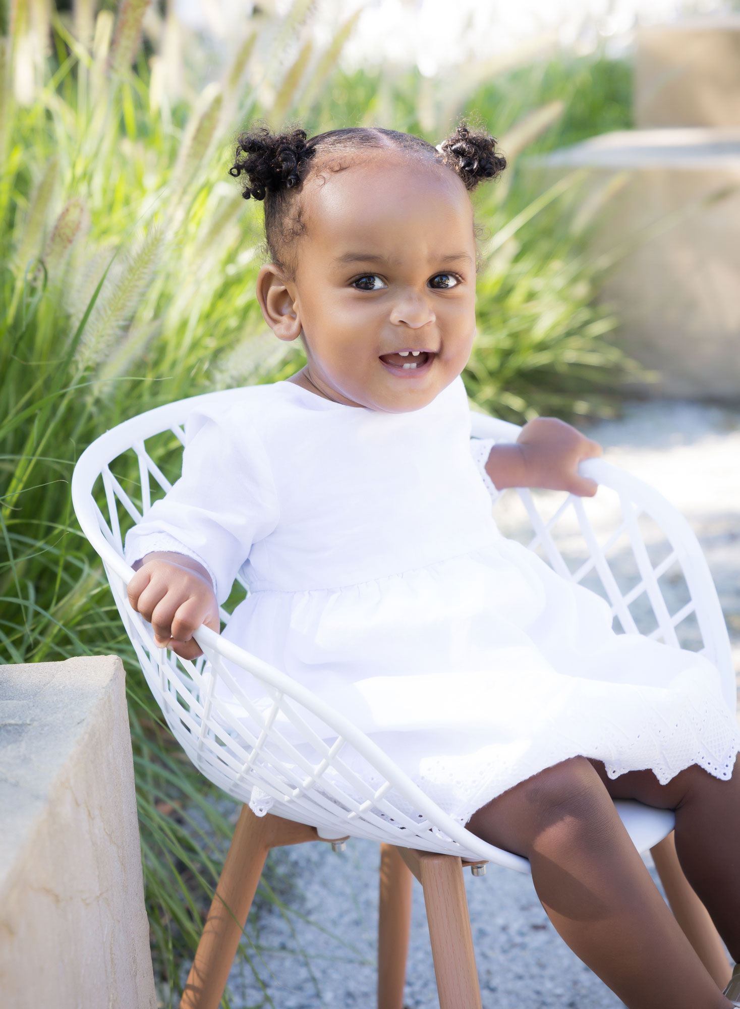 little girl on white chair smiling