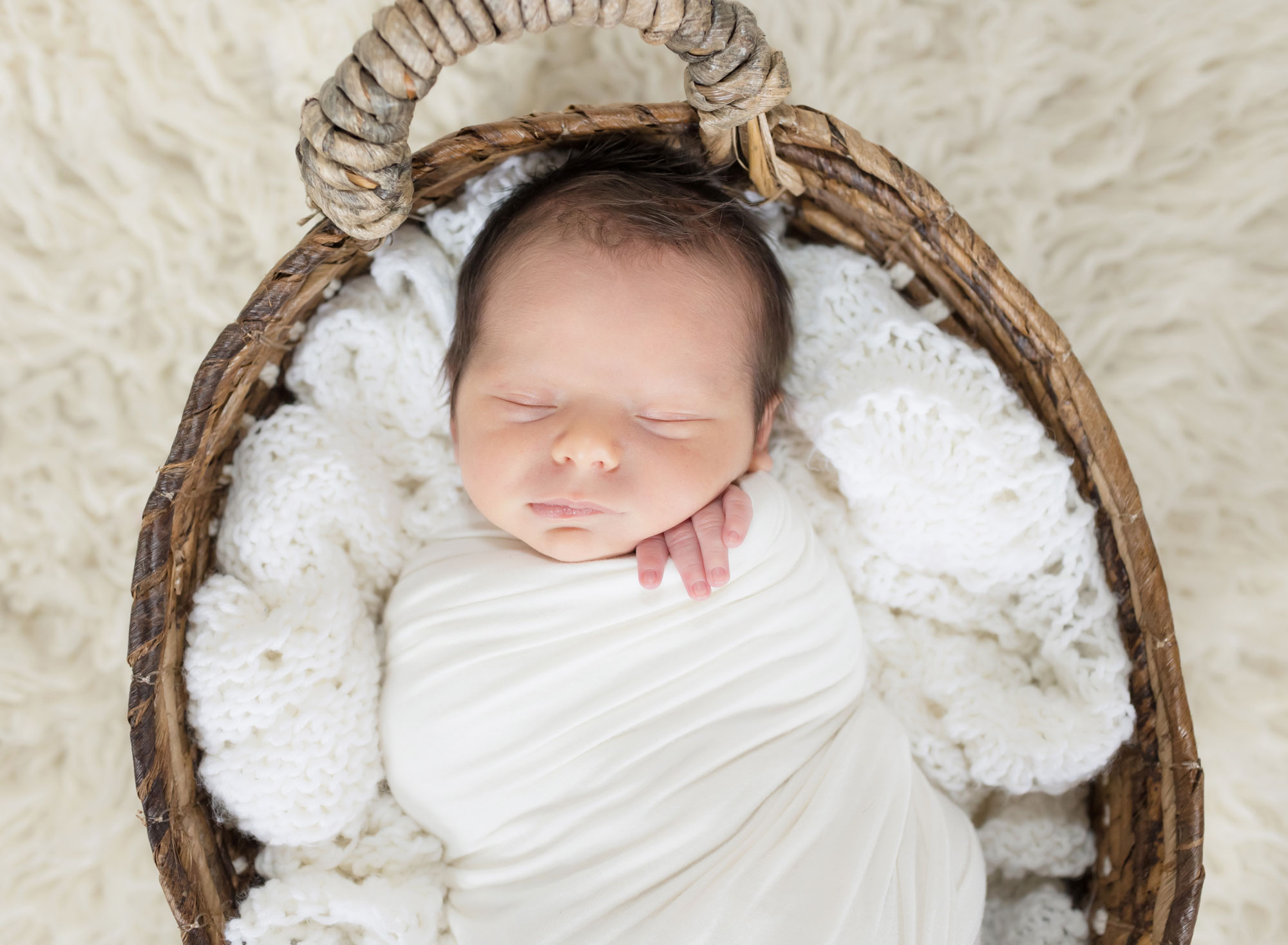 newborn baby boy in white and basket