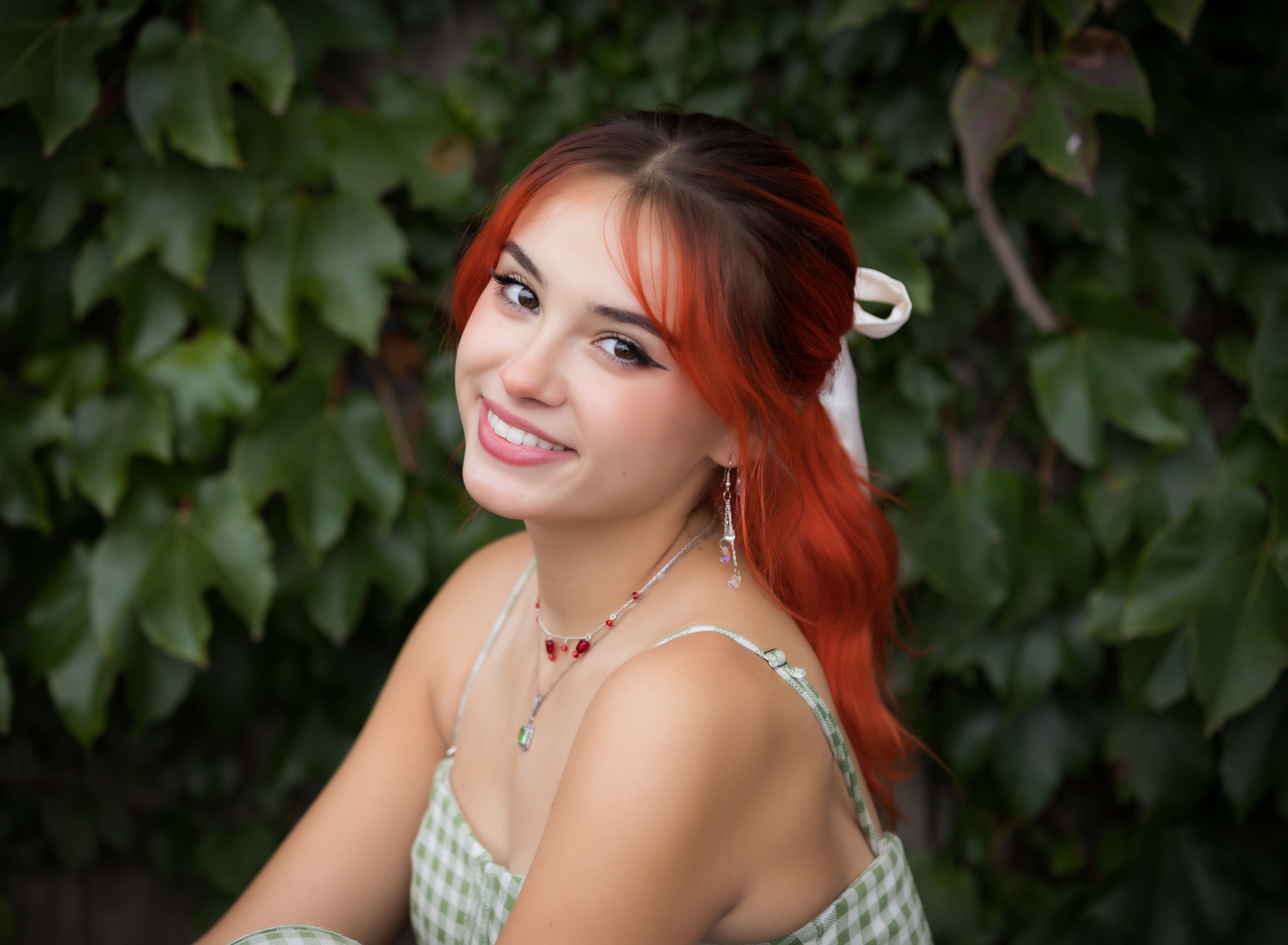 red-headed-senior-girl-sitting-in-front-of-ivy