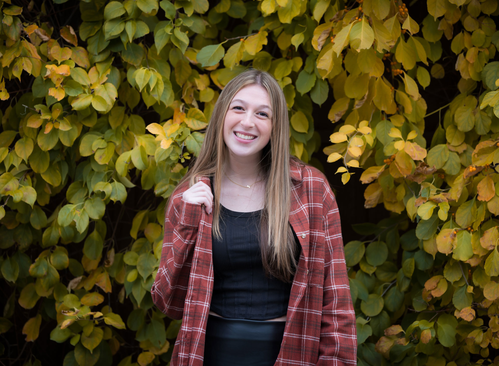 senior girl in flannel shirt smiling at camera