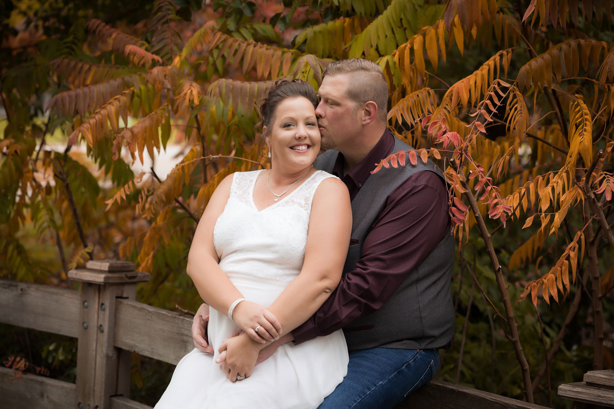 wedding couple kissing in front of fall fronds