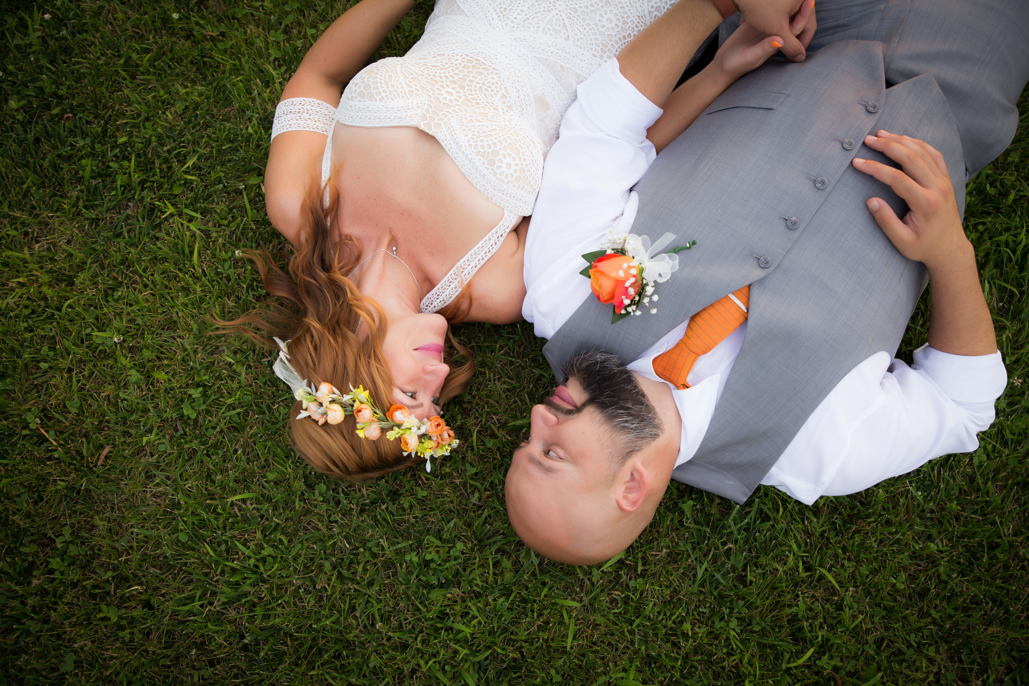 wedding-couple-laying-on-the-ground-looking-at-eachother